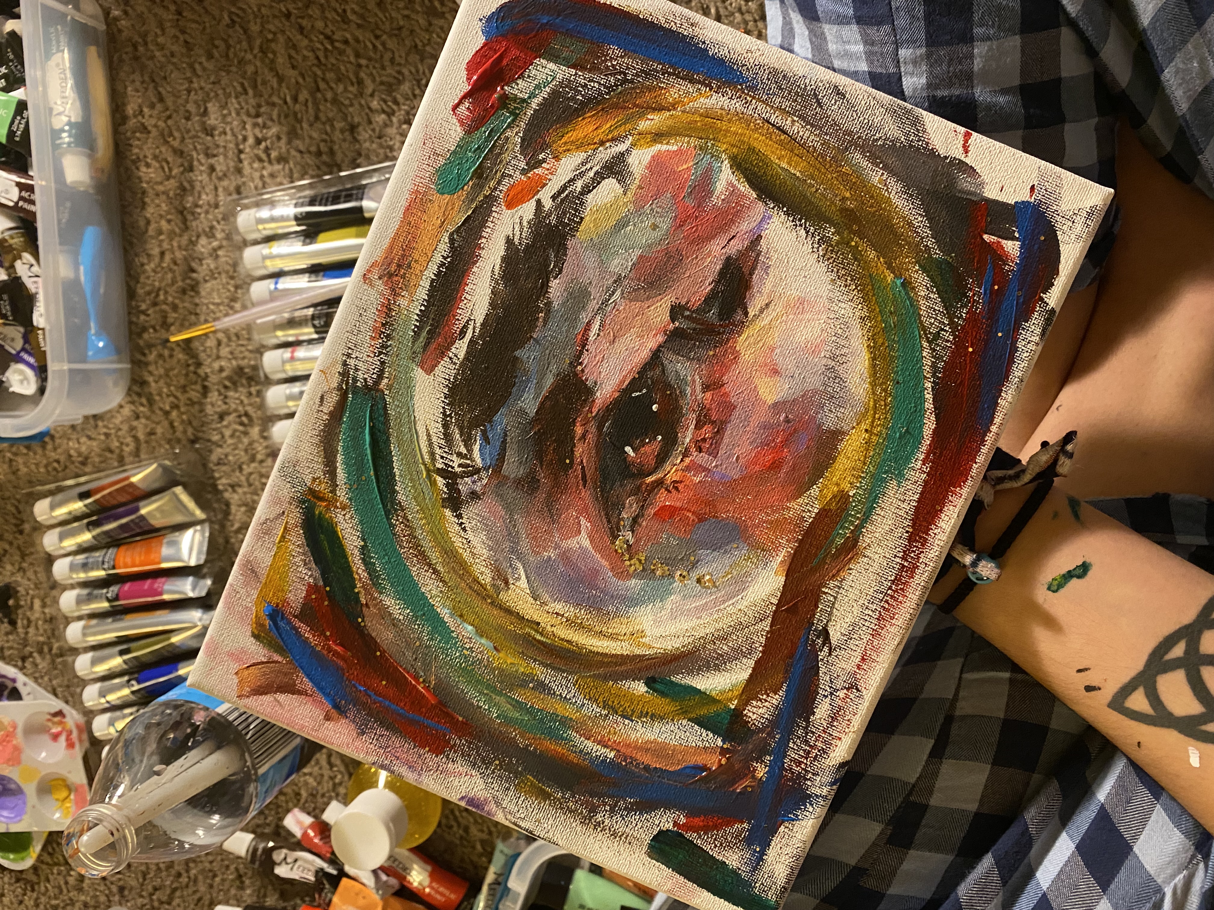 Colorful eye painting surrounded by art supplies